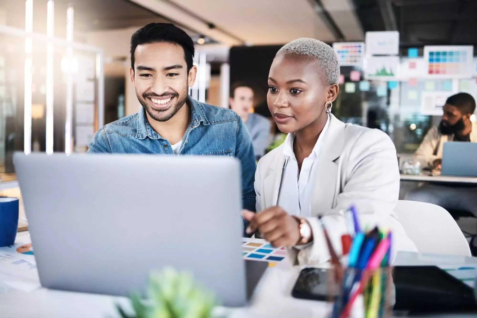 Business people, teamwork and laptop planning in creative agency for project, information or collaboration. Man, woman and diversity of employees at computer for feedback in coworking startup company.