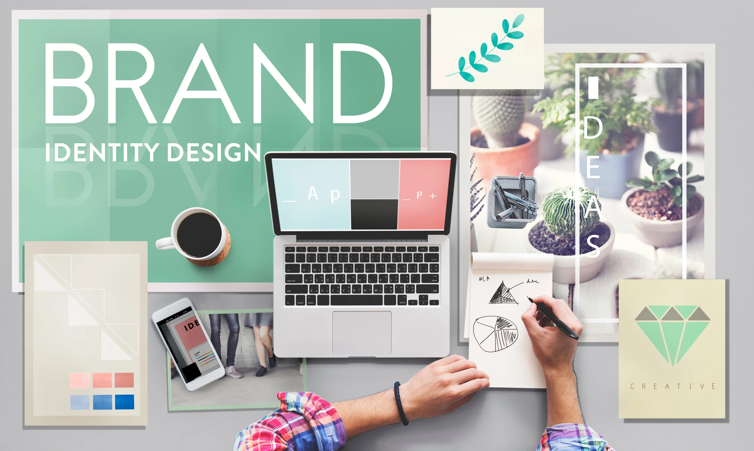 A workspace with a laptop, coffee, sketches, smartphone, and plant images, centered around a “Brand Identity Design” board—perfect inspiration for affordable web design services and creative ideas for small business website design.