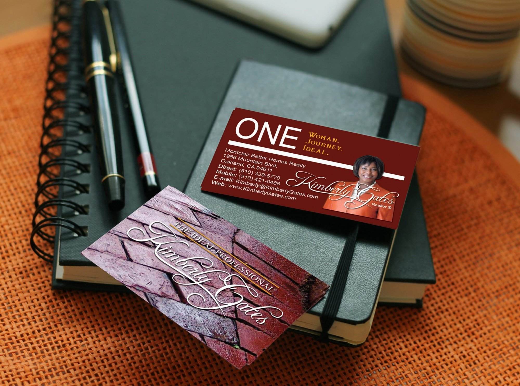 Two business cards for Kimberly Gates rest on a closed black notebook with a pen, beside a cup and plate on a wooden surface—perfect inspiration for small business website design or an affordable web design services showcase.