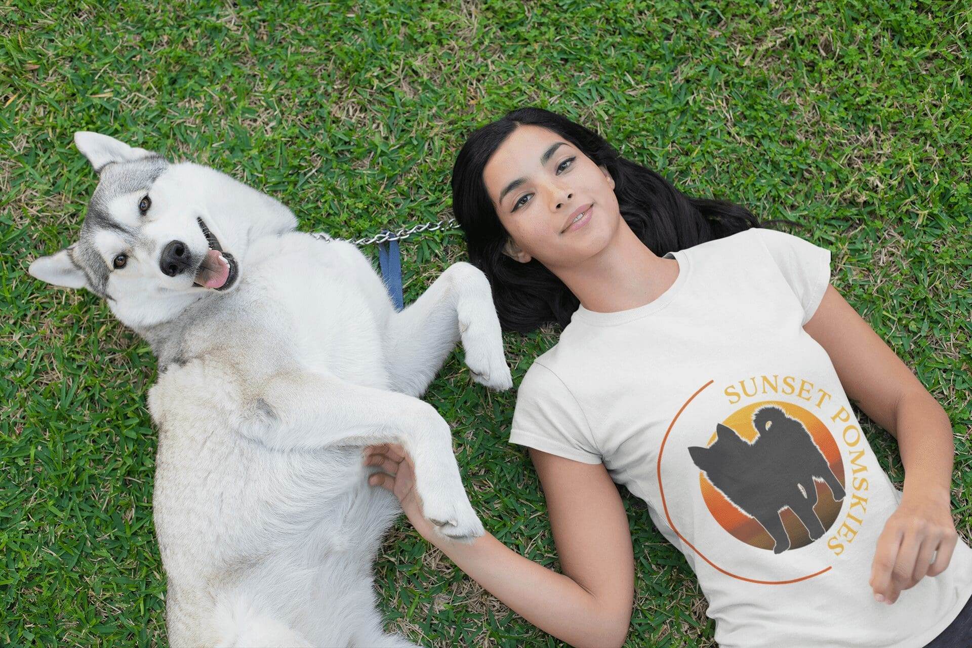 Portfolio A woman lies on grass next to a Siberian Husky, wearing a white “Sunset Pomskies” T-shirt. As she rests her hand on the dog’s paw, she dreams of launching her small business website design with a professional website design company.All-inclusive Website Design Services
