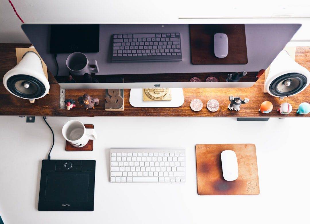 Top Website Builder for Non-Profits Revealed Overhead view of a tidy desk with a computer monitor, keyboard, mouse, and drawing tablet—perfect for a professional website design company or WordPress web designer dedicated to organized, creative small business website design.