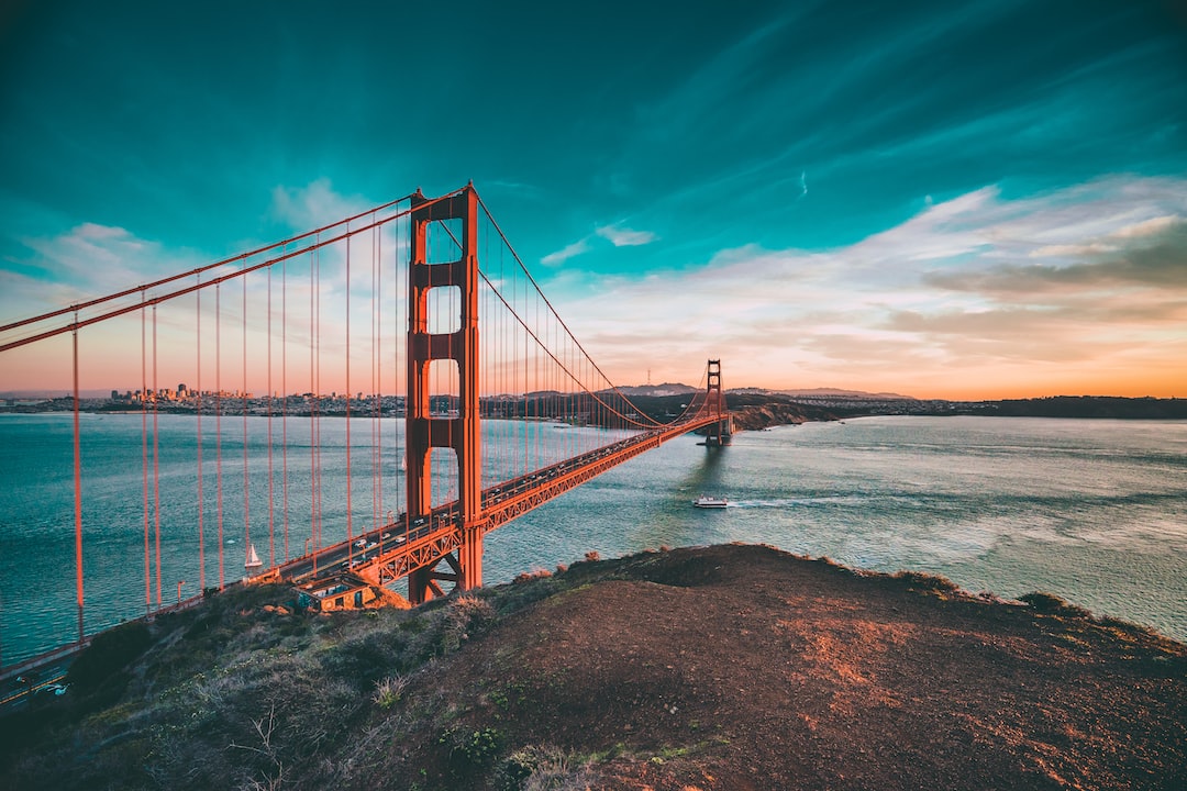 The Golden Gate Bridge spans the San Francisco Bay at sunset.